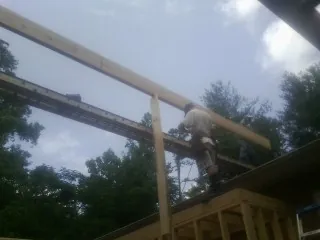 Carpenter setting a ridge beam over a new addition frame — Ice Dam Removal by Roofing Brothers in Rhine