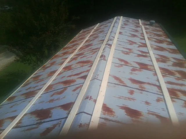 Rusted metal roof panels with new wood purlins before replacement — Storm Damage Roof Repair in Rhine by Roofing Brothers