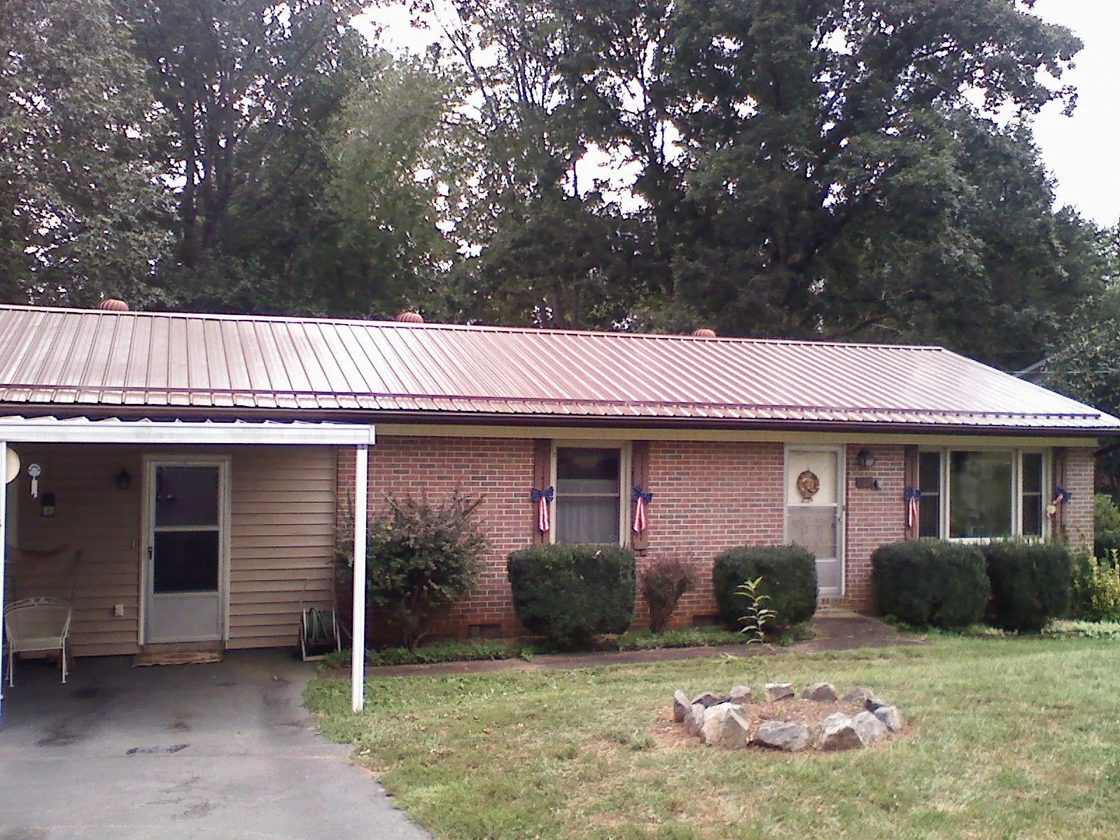 Bronze metal roof and carport on a brick ranch home — Roof Repair work by our crew in Rhine