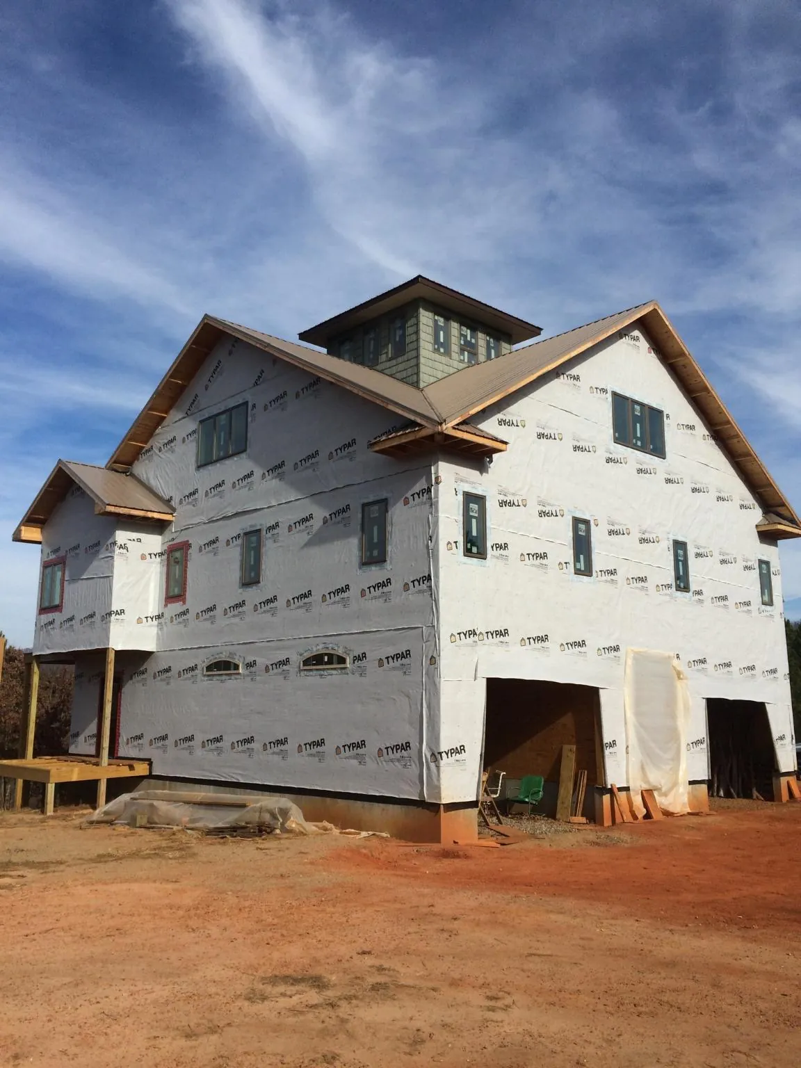 New two story house under construction with a cupola and gabled roofs in Rhine